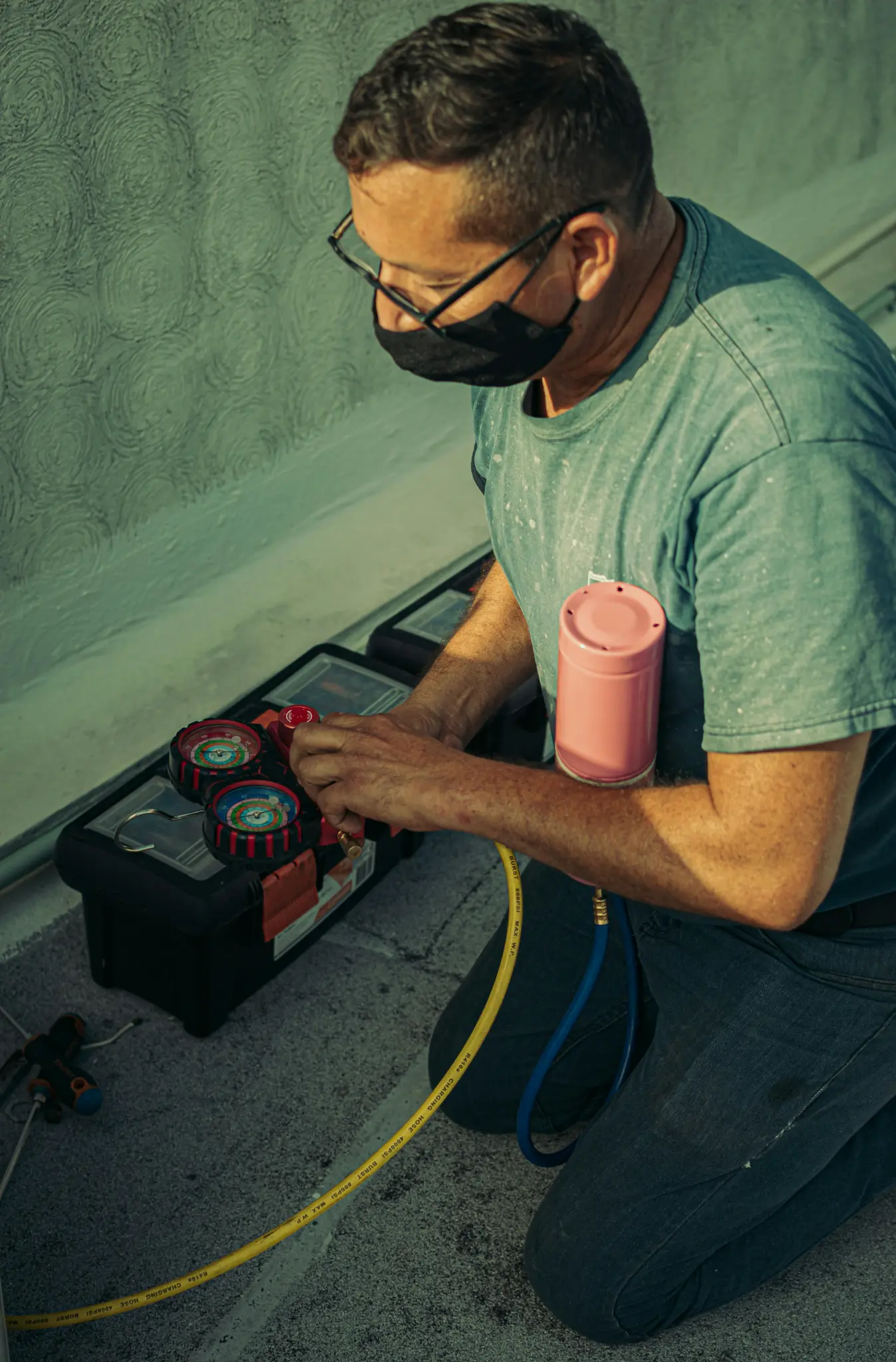 HVAC technician using diagnostic equipment on refrigerant system