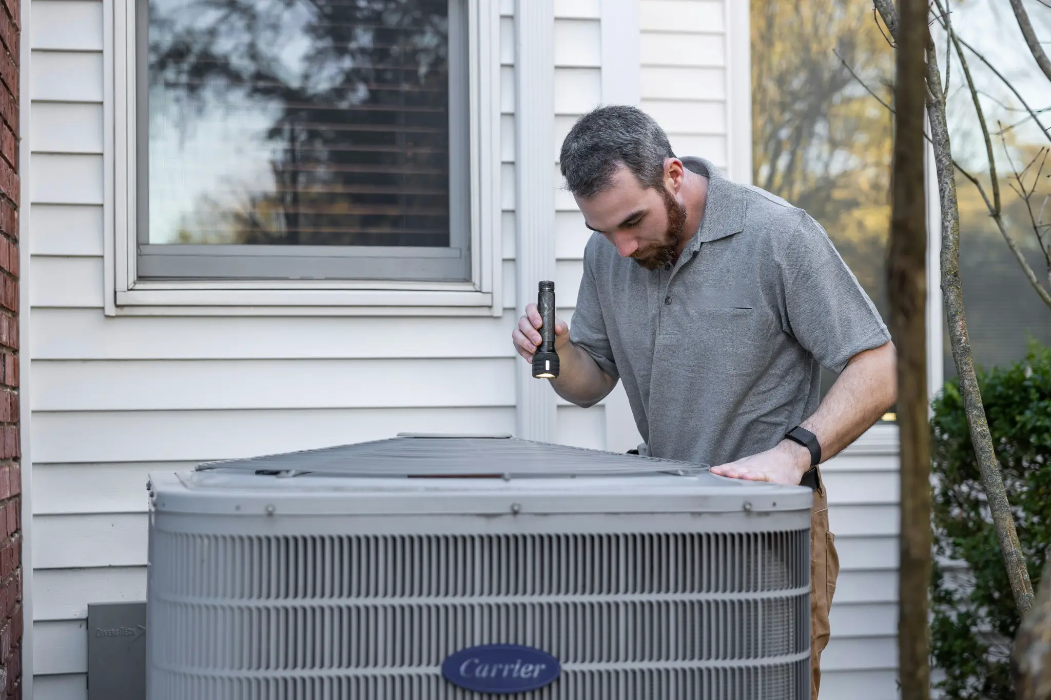 HVAC technician inspecting outdoor AC unit