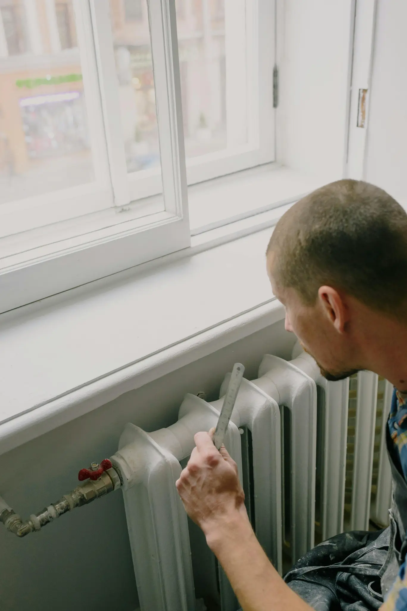 Technician adjusting heating system radiator valve